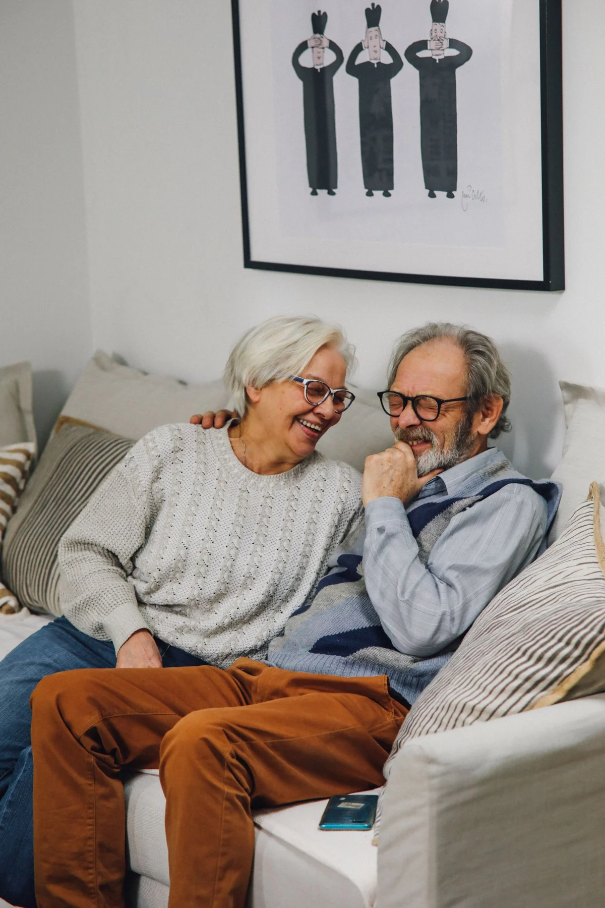 An older couple sharing a smile on their sofa